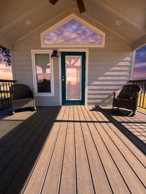 Covered porch of The Waxahachie Tiny Home at sunset