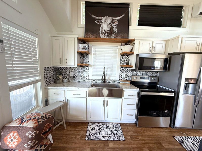 Full kitchen with stainless appliances in The Waxahachie Tiny Home