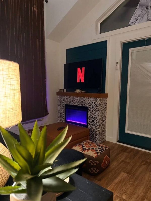 The Waxahachie Tiny Home living room with the LED fireplace glowing on a winter evening